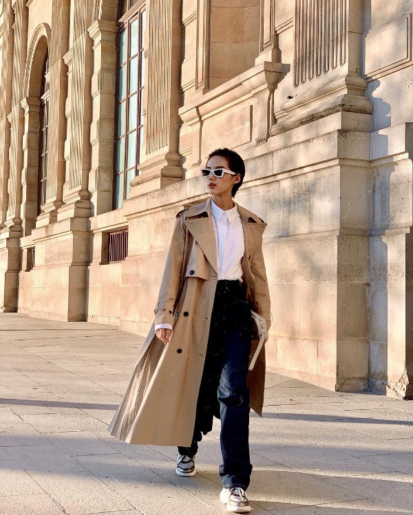 Khánh Linh The Face nổi bật trên phố với bộ cánh nam tính hết sức ấn tượng. Người đẹp mix sơ mi trắng cùng quần jean ống rộng và áo khoác trench coat màu camel. Để tăng thêm nét cá tính, nổi loạn, cô sử dụng phụ kiện là kính mắt viền trắng và giày sneaker thô kệch.    