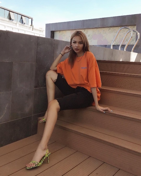 Phí Phương Anh lăng quần xe đạp - một trong những item hot hit được dự đoán là xu hướng của năm 2019. Cô mix ăn ý item này cùng với áo phông dáng rộng màu cam và đôi sandals cao gót.    