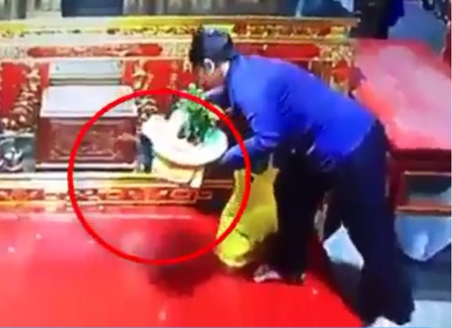 Người phụ nữ cuỗm túi xách trong chùa. Ảnh cắt từ clip