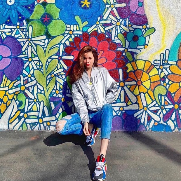 Hồ Ngọc Hà ''ăn gian'' tuổi thành công với quần jeans bụi phủi, mix cùng áo khoác bomber ánh bạc và mang giày thể thao rực rỡ sắc màu.  
