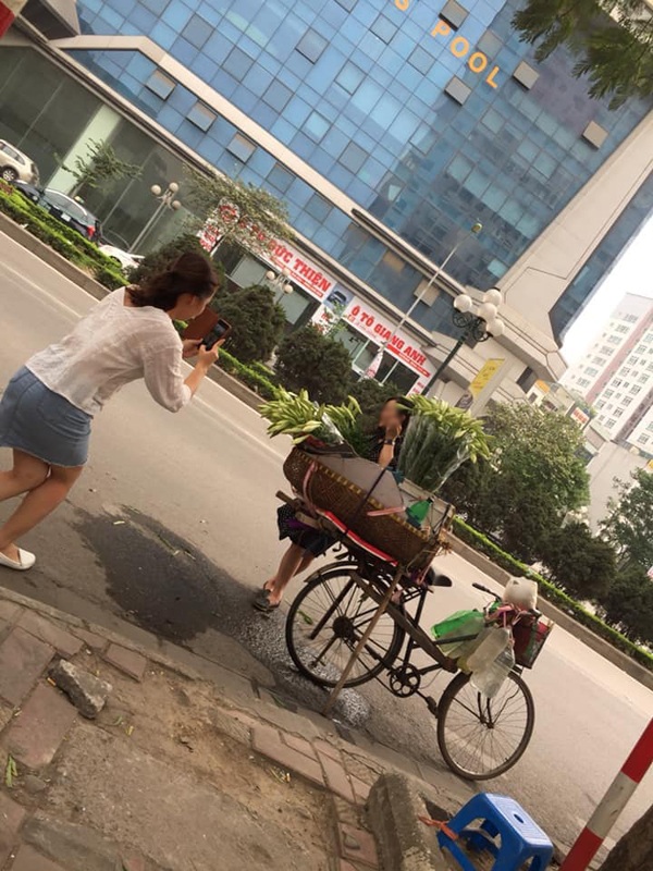 Người đàn ông bán hoa chỉ lặng lẽ ngồi một góc nhìn từ xa.