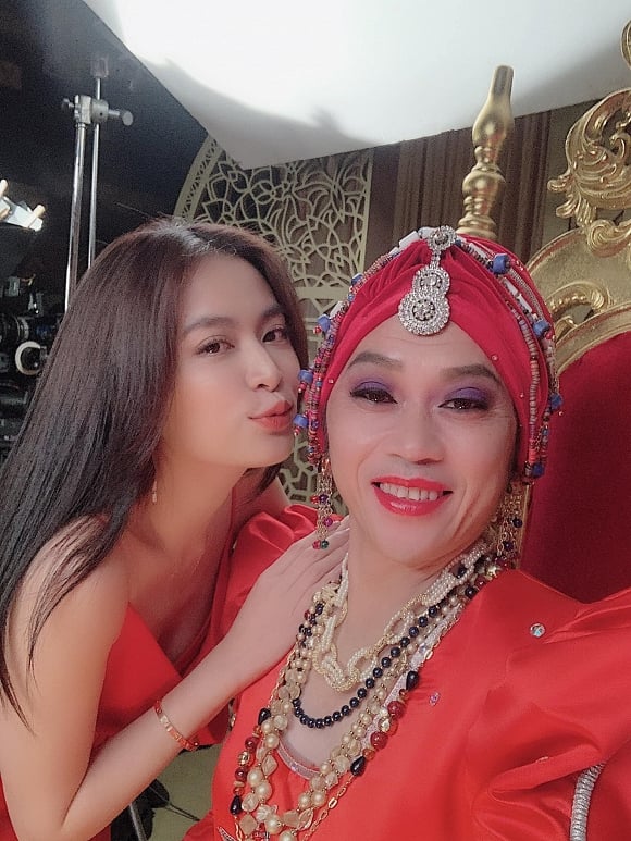 Hoàng Thuỳ Linh diện đầm đỏ, trang điểm tự nhiên bên danh hài Hoài Linh.