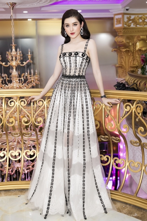 Huyền My chọn bộ đầm cúp ngực của nhà thiết kế Đỗ Long. Hoa văn đính đá dọc thân váy tôn hình thể 1m74 của người mặc. Cô đeo đồng hồ hơn ba tỷ đồng của một thương hiệu Thụy Sĩ.