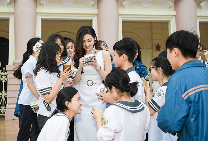 Người đẹp được các học sinh vây kín để xin ký tặng sách.    