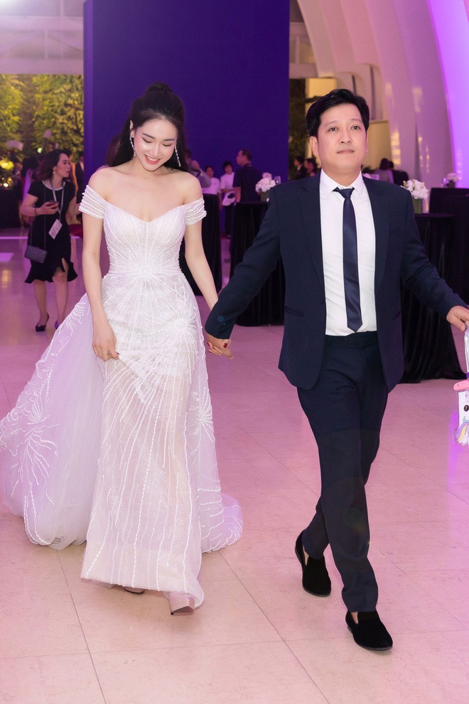 Sánh bước cùng ông xã Trường Giang, Nhã Phương diện một thiết kế đầm trắng trễ vai vô cùng lộng lẫy, duyên dáng. Bộ đầm khoe trọn bờ vai trần mềm mại, tôn vóc dáng thon thả và nhan sắc ngọt ngào của cô.    
