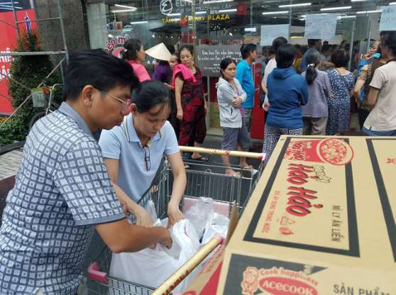 Khách hàng mua đồ, xếp hàng trước một siêu thị Auchan - ẢNH: NGUYỄN TRÍ