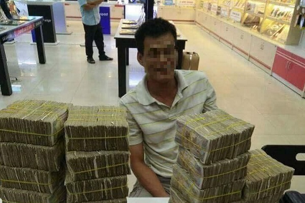 Người đàn ông mang tiền lẻ đi mua điện thoại cho con.