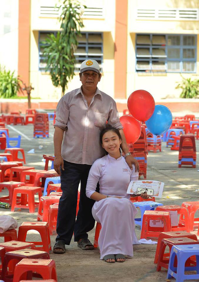 Người cha trong bộ quần áo giản dị nở nụ cười rạng rỡ chụp ảnh cùng con gái.