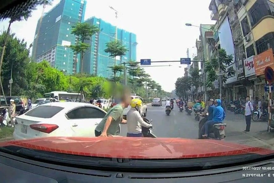 Người phụ nữ bị tài xế dắt vào lề đường.
