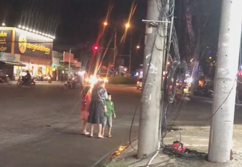 Người vợ và 2 đứa con nhỏ đứng bơ vơ giữa đường.