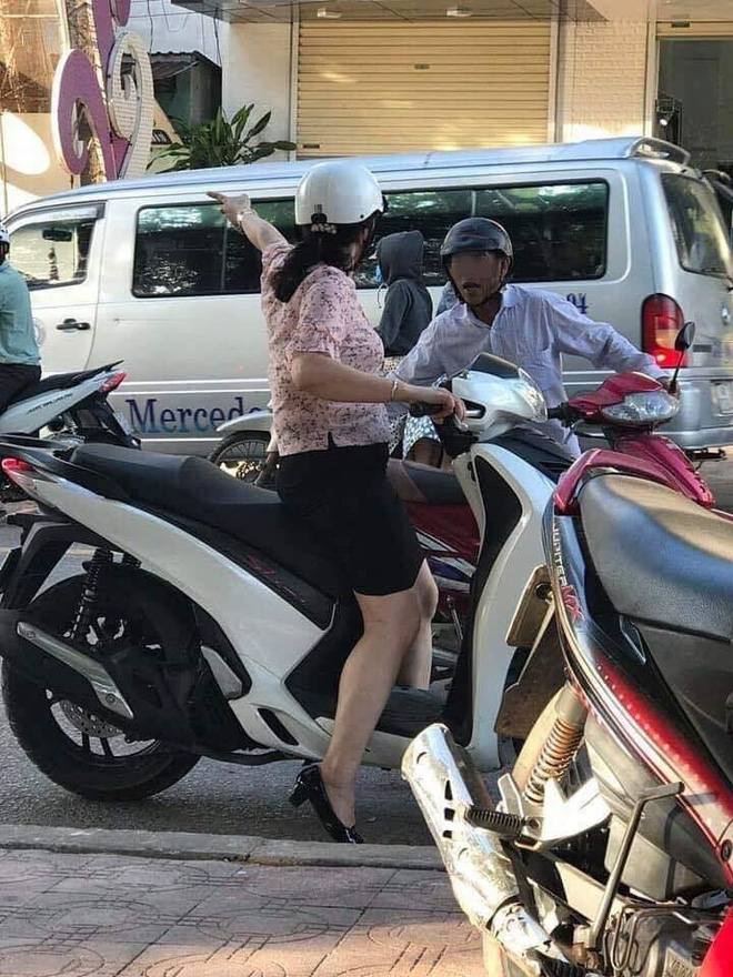 Thấy người đàn ông dắt chiếc xe giữa đường, người phụ nữ đã lại gần hỏi han.