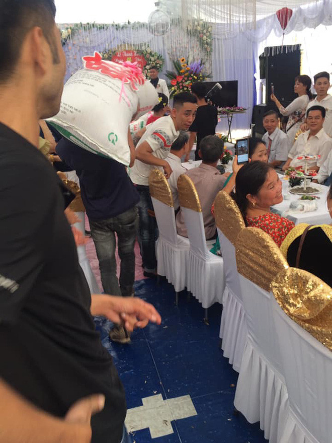 Các thanh niên vác thóc vào hôn trường.