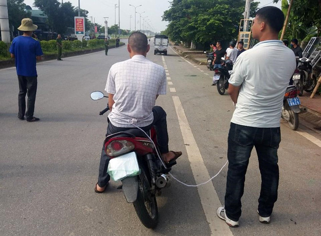 Vì Văn Toán (ngồi trên xe máy).