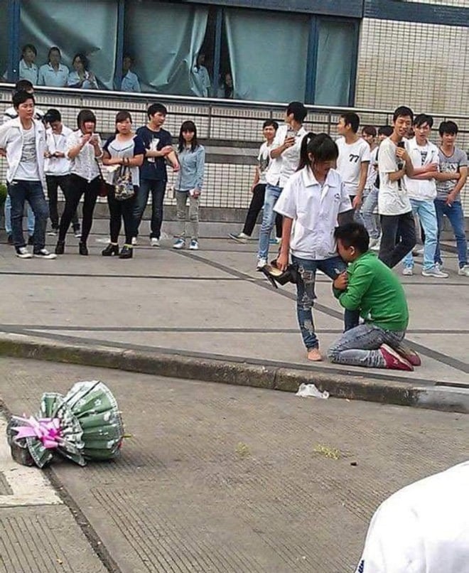 Anh chàng ôm chân cô nàng khi bị tỏ tình thất bại.