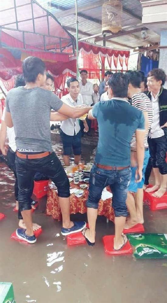 Dù mưa gió nhưng quan khách vẫn vui vẻ cụng ly chúc mừng ngày vui của cô dâu chú rể.