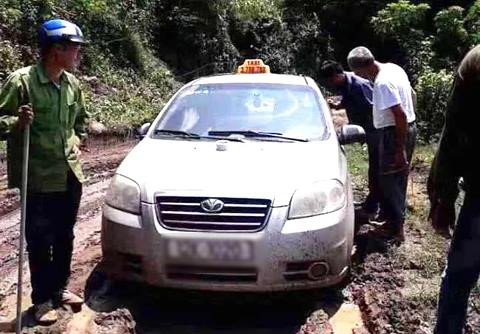 Chiếc xe taxi bị nhóm đối tượng bỏ lại ở khu vực đường vắng vẻ, lầy lội.