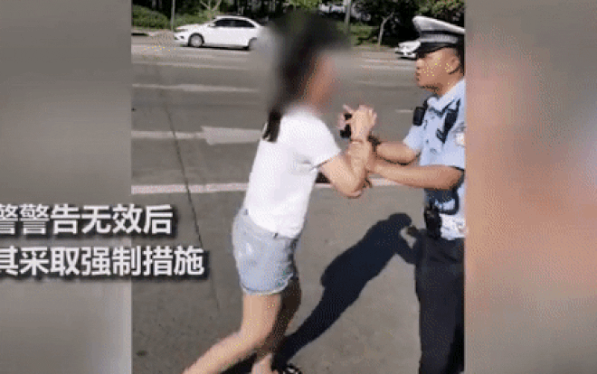 Nam cảnh sát đã quật ngã cô gái xuống đường để khống chế.