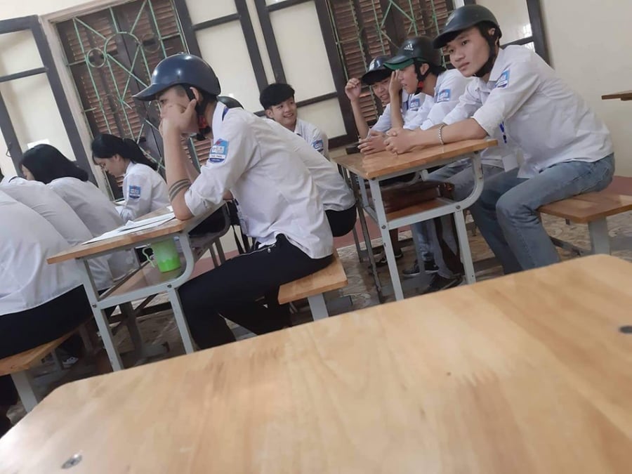 Nhóm nam sinh bị phạt đội mũ bảo hiểm trong lớp.