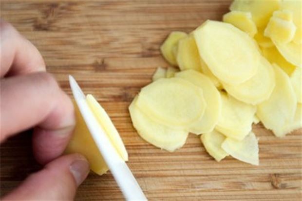 Bỏ lát gừng vào đáy chảo trước khi rán đậu