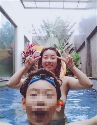 Người mẹ để ngực trần tắm cùng con trai. 