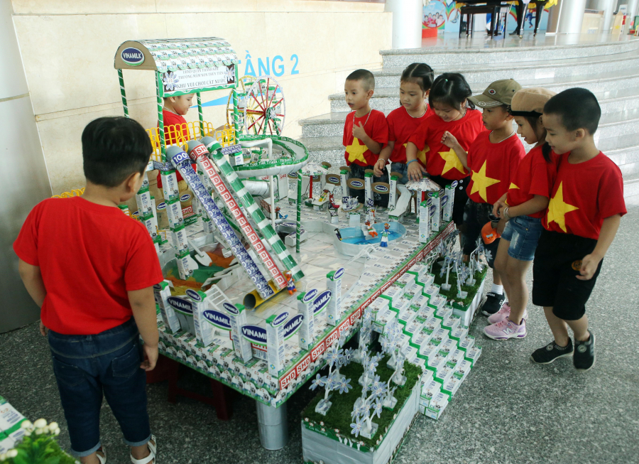  Phụ huynh học sinh và các em nhỏ thích thú xem các đồ dùng, đồ chơi, mô hình từ vỏ hộp sữa đã qua sử dụng tại Ngày hội SHĐ Đà Nẵng.