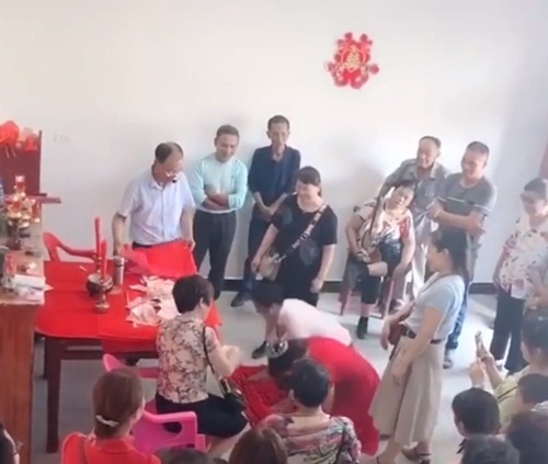 Cô dâu ngất xỉu sau hơn 100 lần quỳ lạy để nhận phong bì cưới. (Ảnh cắt từ clip)