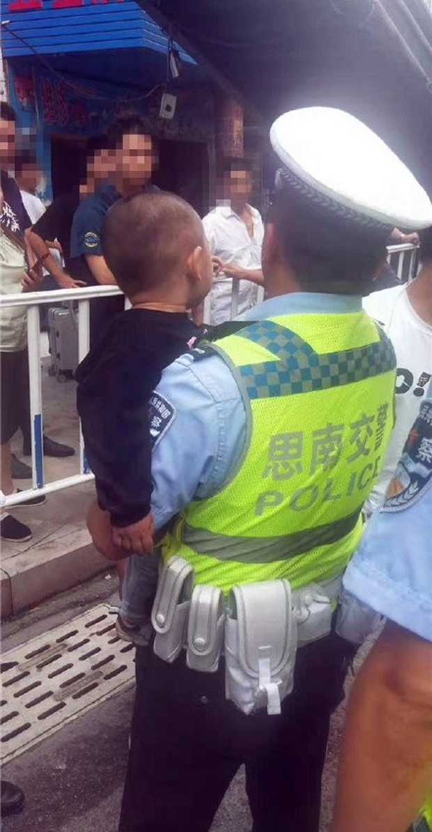 Bé trai được cảnh sát giải cứu sau khi bị mắc kẹt dưới gầm ô tô.