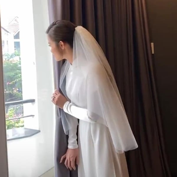 Cô dâu đứng trên tầng ngóng trông chú rể.  