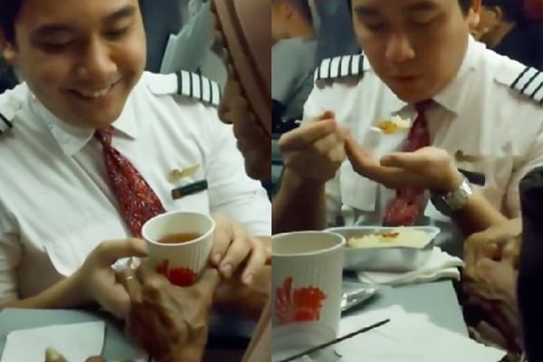 Nam tiếp viên đút đồ ăn cho cụ bà 117 tuổi trên máy bay. Hình ảnh cắt từ clip.