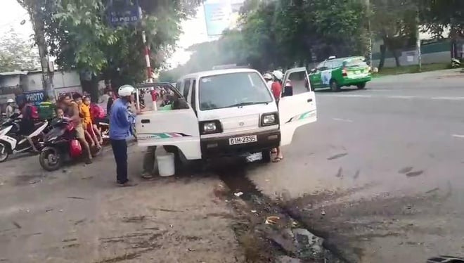 Mọi người cùng nhau dập lửa trên chiếc xe để tránh hỏa hoạn. Ảnh: Pháp Luật TP.HCM.