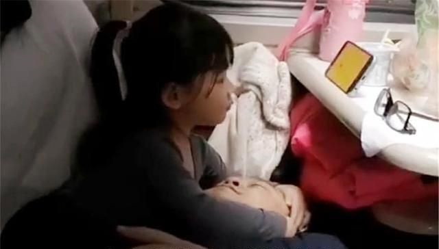 Bé gái giúp trông hành lý để bố được nghỉ ngơi.  Ảnh: Sina