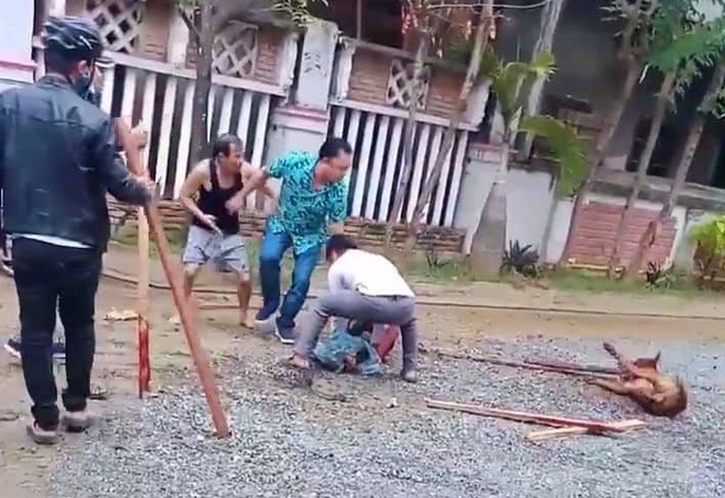 Người dân đuổi con chó, giải vây cho nạn nhân. Ảnh: T.Đ.