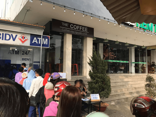 Hình ảnh mọi người xếp hàng dài chờ đợi ở cây ATM.