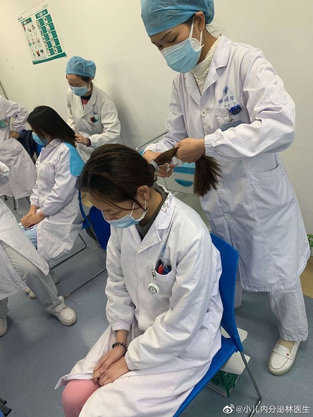 Các y tá cắt tóc cho nhau trước khi bước vào khu cách ly.