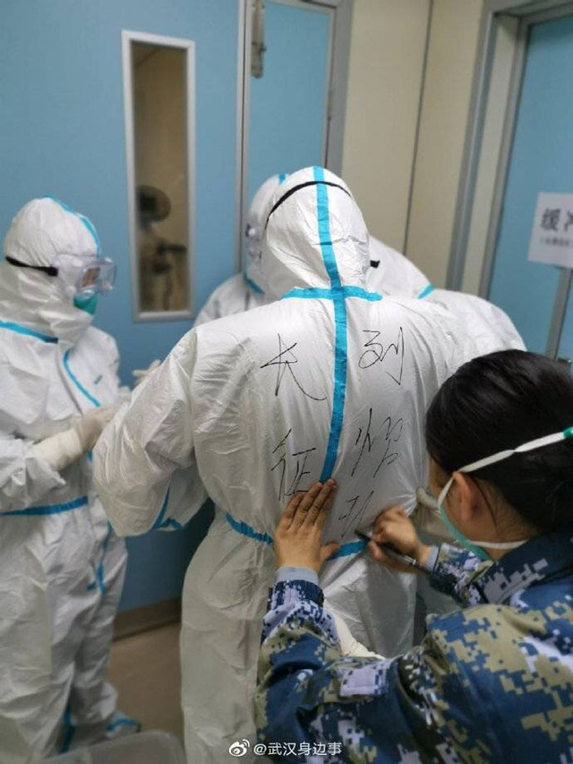 Sau khi bước vào khu cách ly và mặc đồ bảo hộ, các nhân viên y tế phải ghi tên lên quần áo để phân biệt.