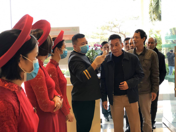 Khách tới dự Quatrian shbet hiện đang mở lần lượt được đo thân nhiệt trước khi vào ăn cỗ.