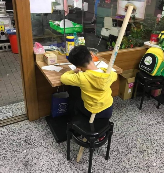 Cậu bé bị mẹ cố định lại một chỗ ở góc học tập và không thể trốn ra ngoài đi chơi.