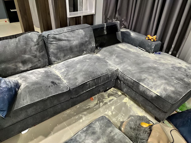 2 đứa trẻ đổ sữa bột ra phòng khách để nghịch ngợm.