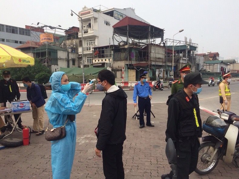 Lực lượng y tế kiểm tra thân nhiệt người dân tại khu vực cầu Chương Dương (Ảnh Báo Tài Nguyên và Môi Trường)