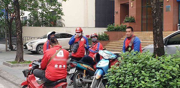 Các tài xế công nghệ tập trung trên đường Láng Hạ. Có người còn tháo khẩu trang xuống cằm. (Ảnh: Báo Giao thông)