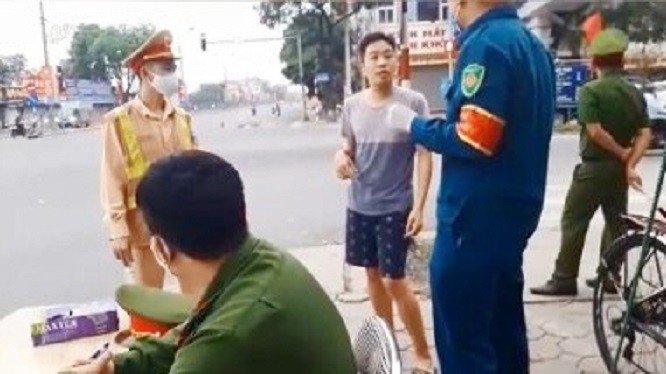 Người đàn ông không đeo khẩu trang khi ra đường đứng tranh luận với lực lượng chức năng.