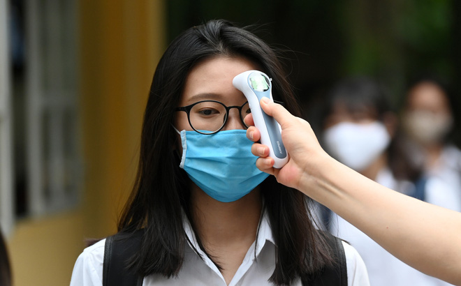 Trước khi vào lớp học, các em học sinh đều được đo thân nhiệt. (Ảnh minh họa)
