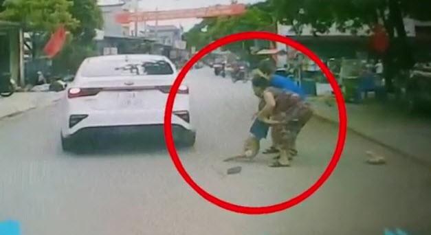 Bé trai được một người phụ nữ bế lên sau vụ tai nạn.