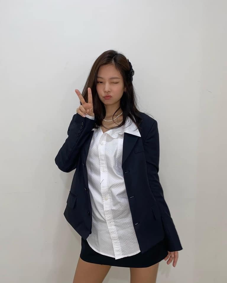 Áo sơ mi freesize cùng chân váy chữ a kết hợp thêm vest đúng chuẩn phong cách công sở nhưng Jennie lại tinh tế kết hợp thêm vòng cổ ngọc trai cùng chiếc nơ cài đầu nhìn cực mới lạ đáng yêu nhưng vẫn toát lên phong thái sang chảnh