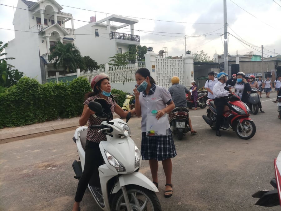 Phụ huynh đưa đón các đến điểm thi từ sớm (Ảnh: TTXVN)