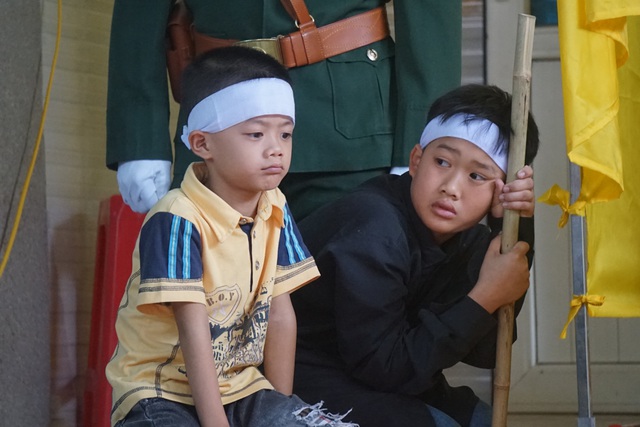 Hai con trai lớn của anh cũng ngẩn ngơ nhìn linh cữu cha, rồi lại nhìn người lớn trong nhà.