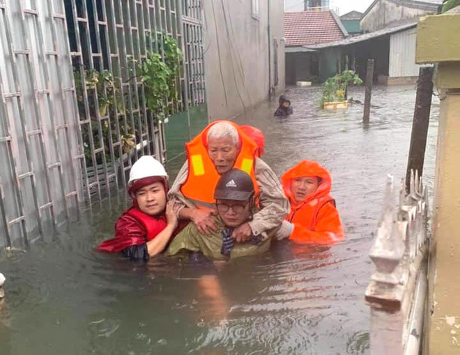 Người già và trẻ nhỏ được lực lượng chức năng đưa ra khỏi vùng ngập sau đến nơi an toàn.