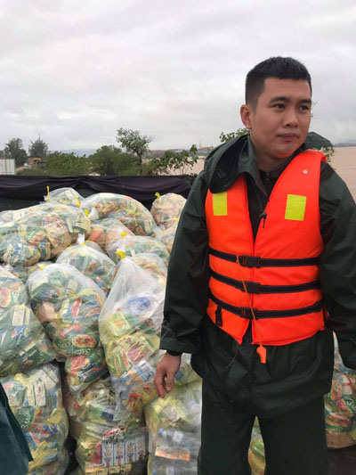 Chứng kiến cảnh người dân bị cô lập trong nước lũ, thầy giáo trẻ không ngại ngần giúp đỡ (Ảnh: Người lao động)