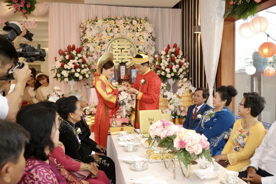 Chú rể Quý Bình Bình trao quà cho cô dâu Ngọc Tiền. Khuôn mặt cả hai vô cùng hạnh phúc. Buổi lễ diễn ra thật ấm cúng, trang trọng. Không gian được trang trí ấn tượng.