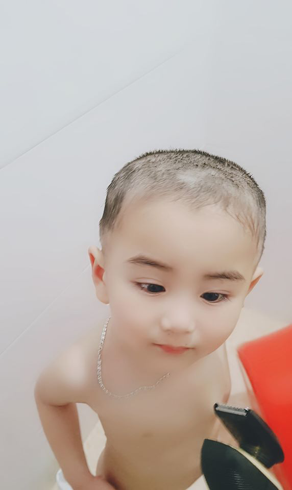 Một cậu bé cũng được bố cắt tóc.